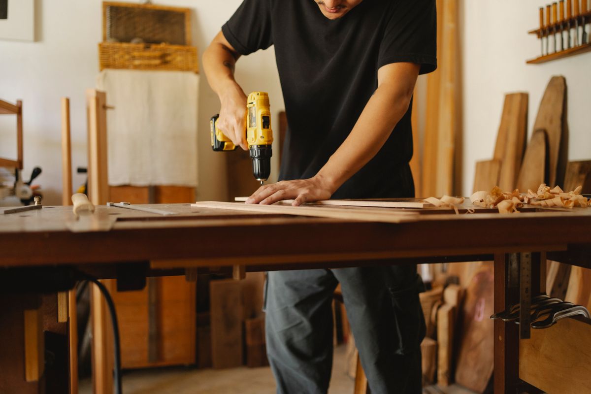 Artisan traitant une pièce de bois en atelier